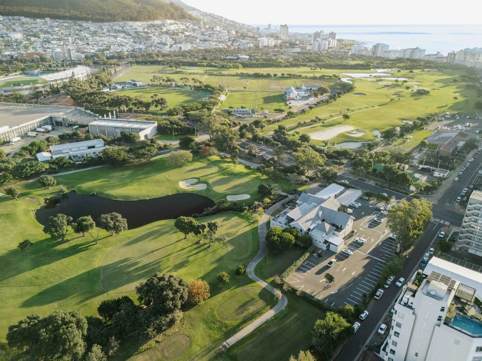 A pond and green from above, with the course stretching towards the sea